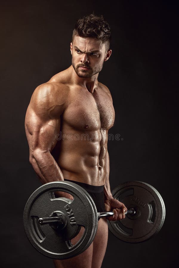 Mięśniowy bodybuilder facet robi ćwiczeniom z dużym dumbbell