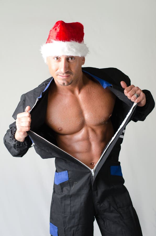 Mięśniowy bodybuilder jest ubranym Święty Mikołaj czerwieni kapelusz obraz stock Mięśniowy bodybuilder jest ubranym Święty Mikołaj czerwieni kapelusz obraz stock