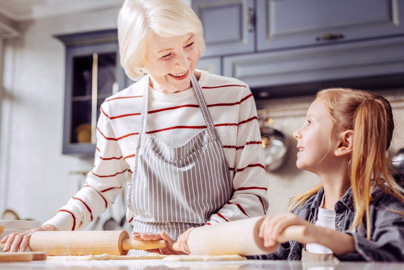Miła babcia ono uśmiecha się podczas gdy gotujący z jej ładną wnuczką obraz stock Miła babcia ono uśmiecha się podczas gdy gotujący z jej ładną wnuczką obraz stock