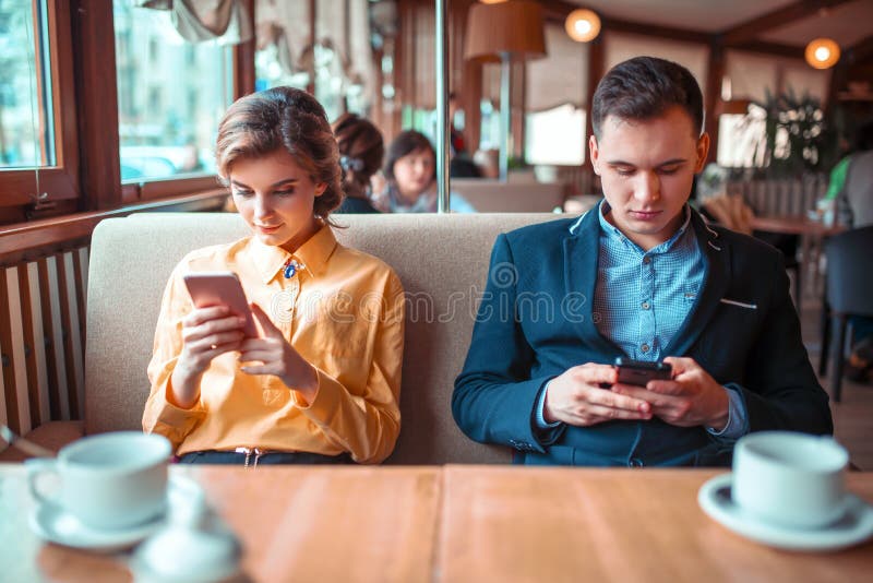 Miłości pary use ich telefony komórkowi w restauraci obraz royalty free Miłości pary use ich telefony komórkowi w restauraci obraz royalty free