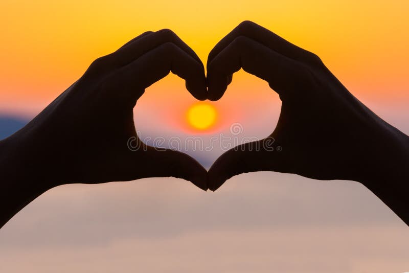 Female hands making a heart shape in the sunset - health, love concept. Female hands making a heart shape in the sunset - health, love concept.