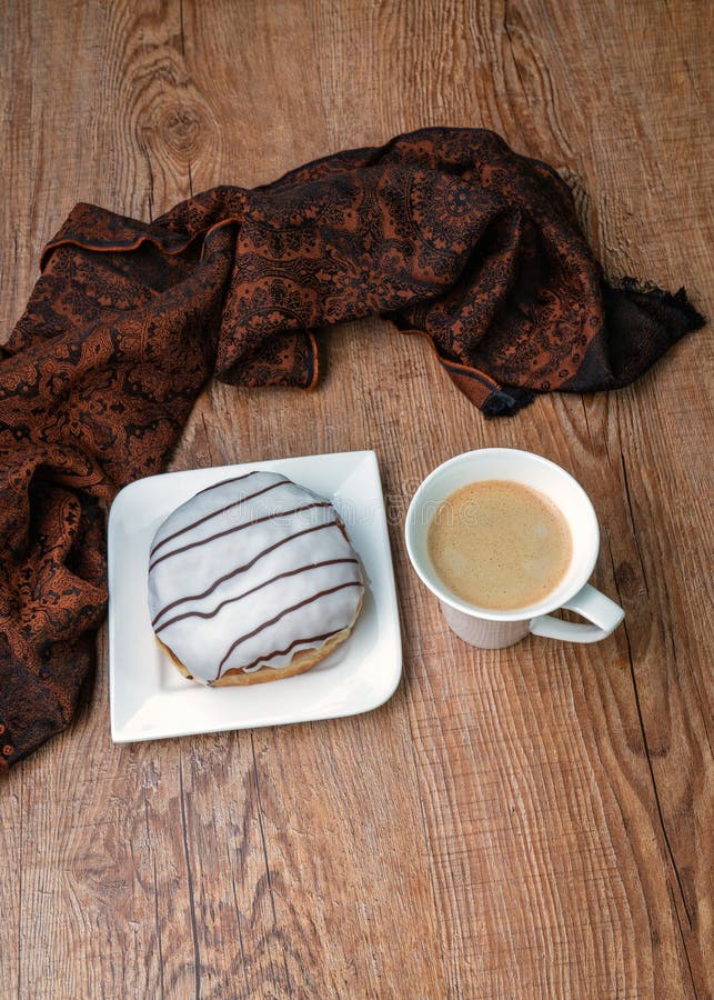 Mjuk åsna med choklad på vit plåt och en kopp kaffe på träbord. Utrymme för översiktskopia royaltyfri fotografi