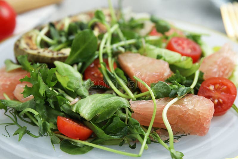 Mjuka pomelosallad med tomater och mikrogreoner på plåtsduk fotografering för bildbyråer