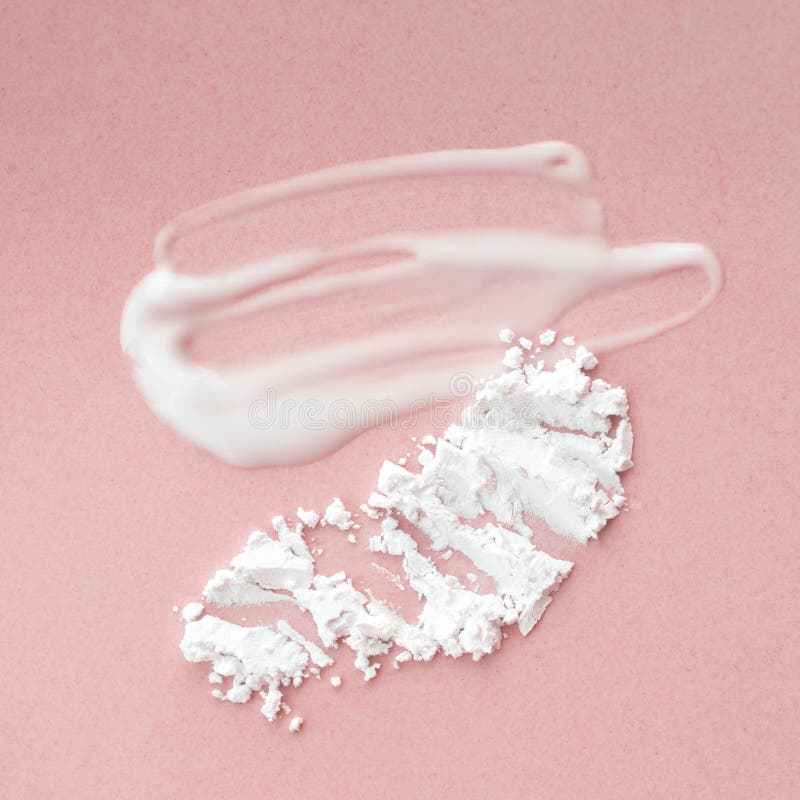 Mjölkgräddspruta och genomskinligt mineralpulver på rosa bakgrund Sköldhet och hudvård arkivbilder