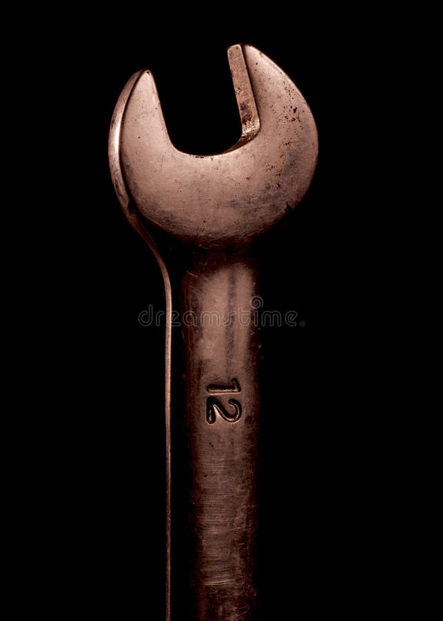 12mm box wrench on a black background. A dirty but shiny 12mm box wrench on a deep black background