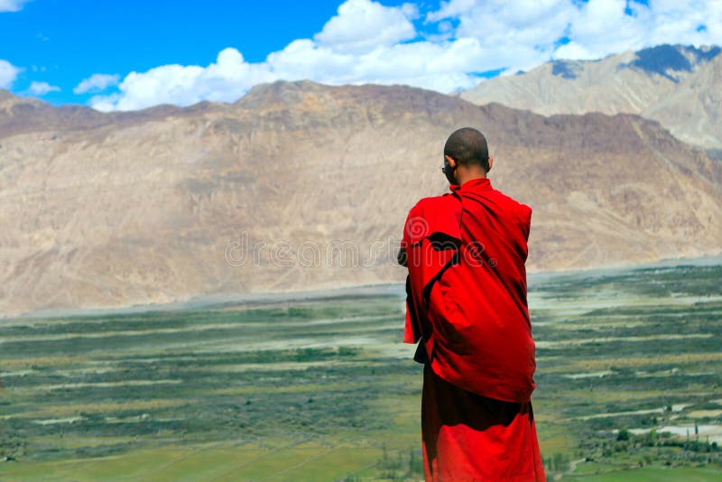 Buddhist monk looks at the Himalayas and valley. Buddhist monk looks at the Himalayas and valley