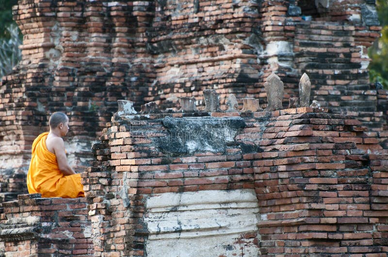 Buddhist monk in meditation at Wat Chai Wattanaram, Ayutthaya, Thailand. The temple was built in 1629 by King Prasat Tong, probably on the site of his mother's cremation. Buddhist monk in meditation at Wat Chai Wattanaram, Ayutthaya, Thailand. The temple was built in 1629 by King Prasat Tong, probably on the site of his mother's cremation.