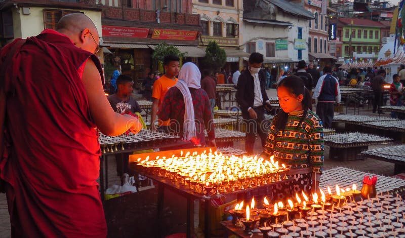 Mnich buddyjski zaświeca ono modli się świeczkę, Boudhanath stupa, Kathmandu, Nepal zdjęcie royalty free Mnich buddyjski zaświeca ono modli się świeczkę, Boudhanath stupa, Kathmandu, Nepal zdjęcie royalty free