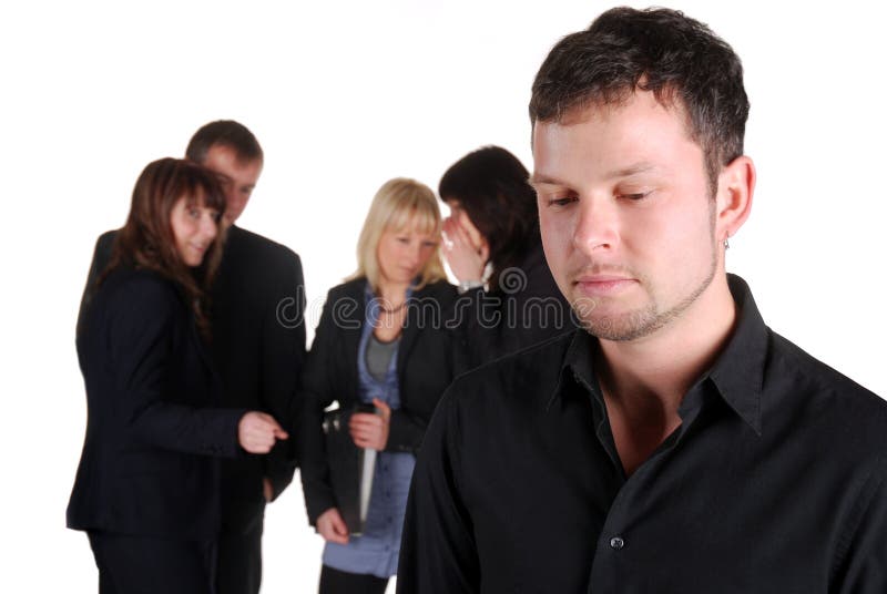 Businessman is sad while a group of business people talks over him. Businessman is sad while a group of business people talks over him.