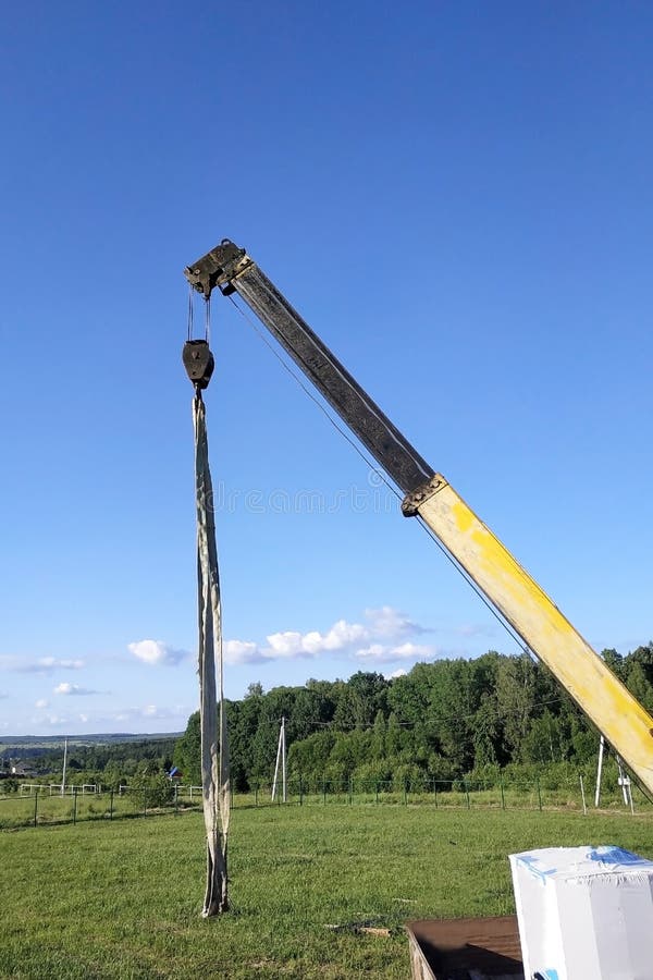 The Mobile Crane Unloads Pallets of Blocks from the Trailer of the