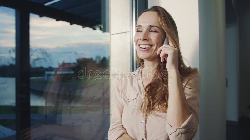 Mobile parlant de femme heureuse dans la maison Portrait de téléphone parlant de sourire de femme