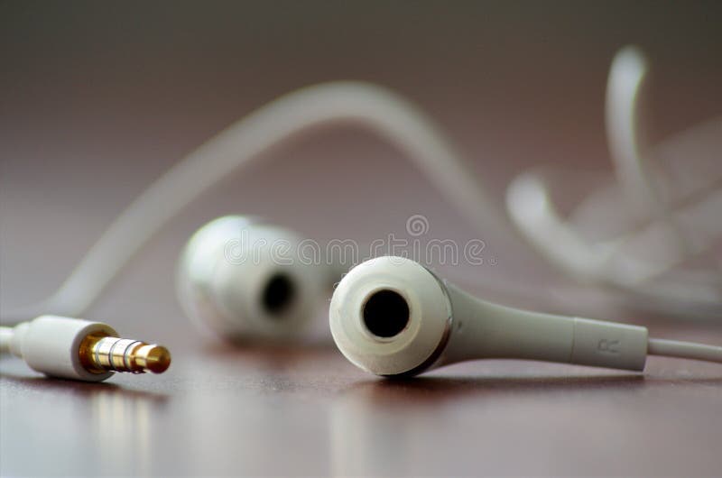 Closeup Macro shot of Iphone or Android white earbuds headphones for playing music. Closeup Macro shot of Iphone or Android white earbuds headphones for playing music.