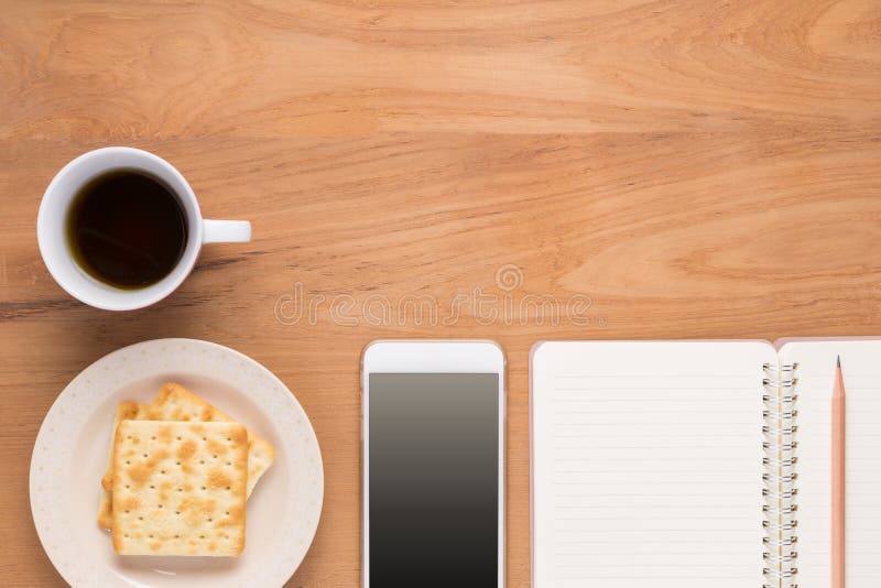 Mobile phone, notebook, pencil, coffee, tea, food cracker