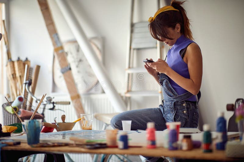 Mobile Photos of Art. Female Artist Using Mobile in Art Studio Stock