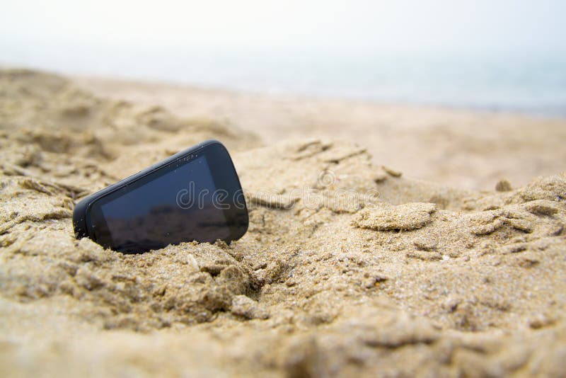 Mobile touch phone in sand on a beach. See my other works in portfolio.