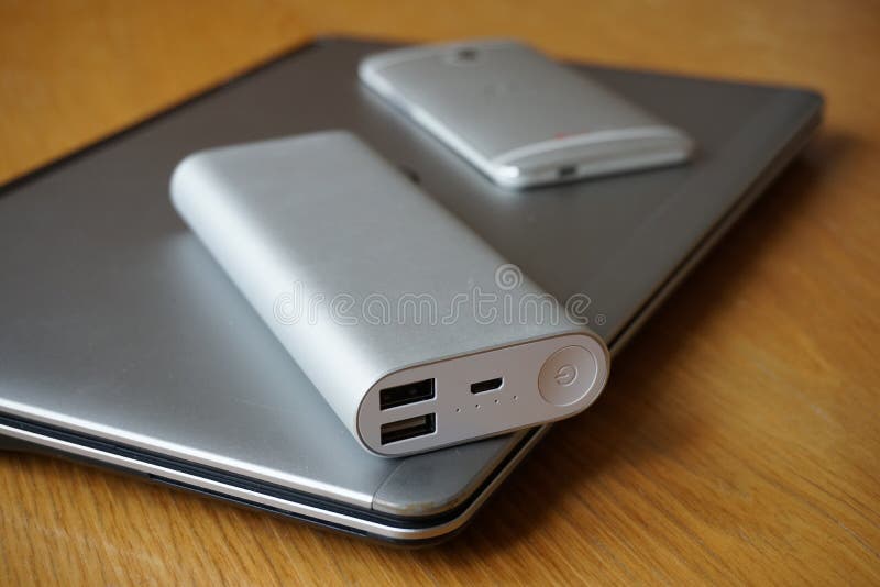 Mobilt kontor med den aluminum bärbar dator-, mobiltelefon- och maktkällan (maktbanken) på trätabellen royaltyfria bilder Mobilt kontor med den aluminum bärbar dator-, mobiltelefon- och maktkällan (maktbanken) på trätabellen royaltyfria bilder