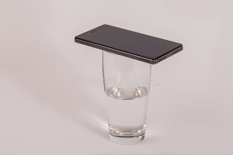 Mobiltelefon på ett exponeringsglas av vatten royaltyfria foton Mobiltelefon på ett exponeringsglas av vatten royaltyfria foton