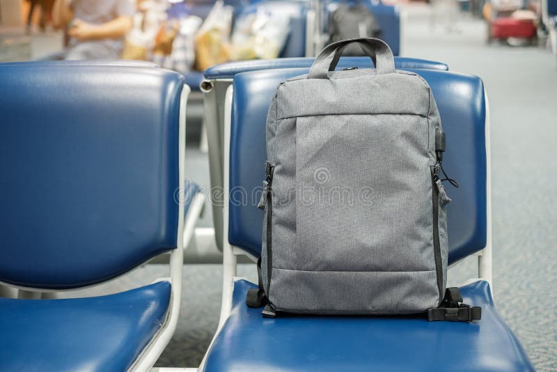 Mochila gris del negocio en asiento en el interior del terminal de aeropuerto Concepto del negocio y del viaje foto de archivo libre de regalías Mochila gris del negocio en asiento en el interior del terminal de aeropuerto Concepto del negocio y del viaje foto de archivo libre de regalías