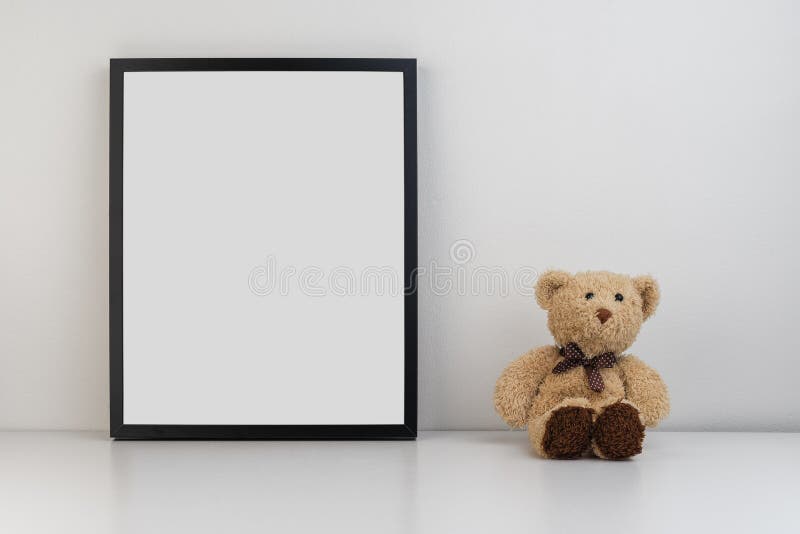 Mock up photo frame on table with a teddy bear as decoration