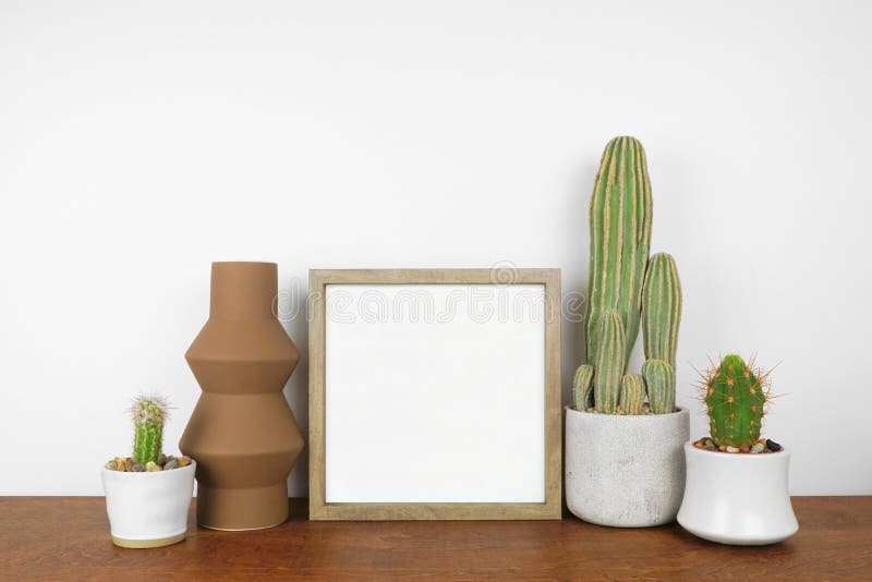 Mock up square wood frame with cactus plants and modern geometric vase on a wood shelf royalty free stock photos