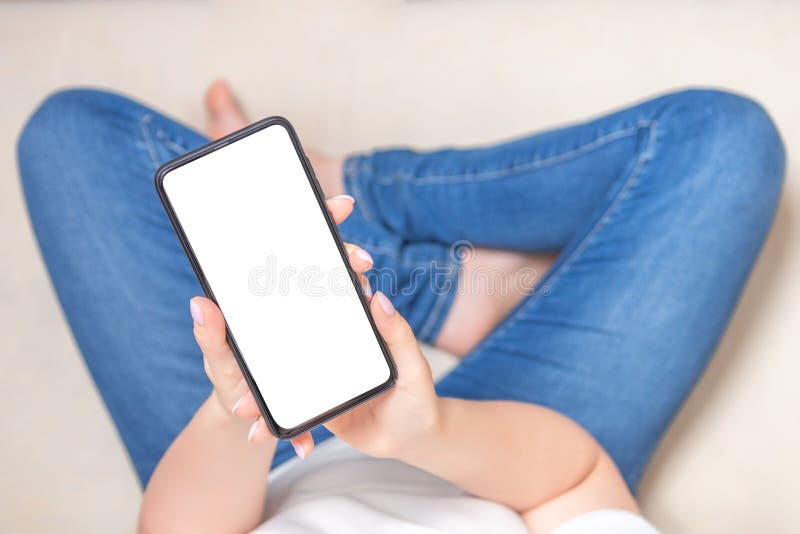 Mockup image blank white screen cell phone. Woman holding texting using mobile phone on sofa at home. cell phone in vertical stock images