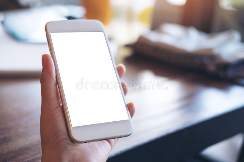 Mockup image of a hand holding white mobile phone with blank screen stock image