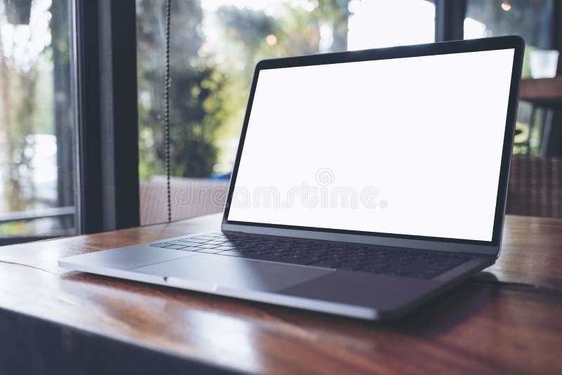 Mockup image of laptop with blank white screen on wooden table near by window stock photo