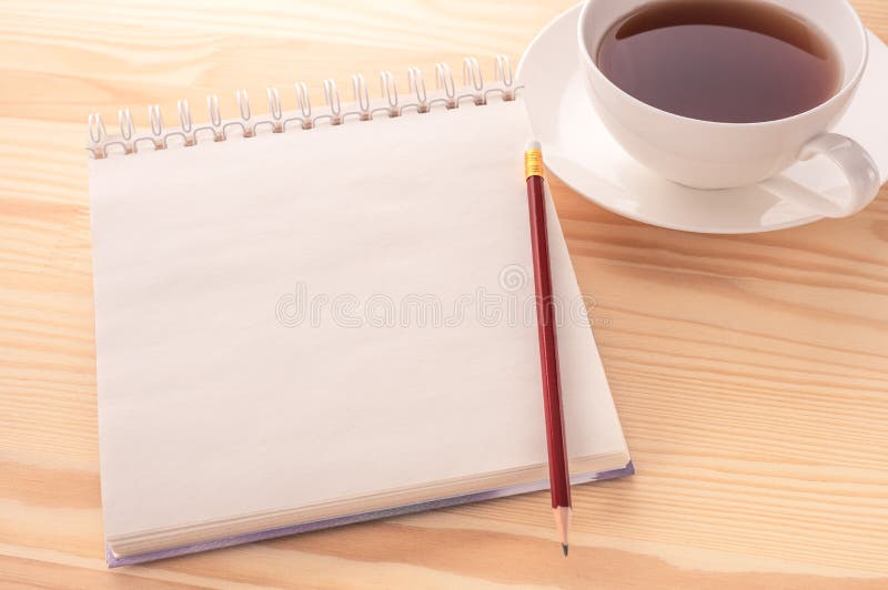 Mockup image. Open blank page notebook with a copy space and cup of tea on a white wooden table background. White paper of stock images