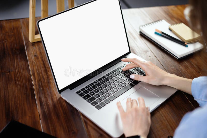 Mockup image of a woman using laptop with blank screen on wooden table stock photo
