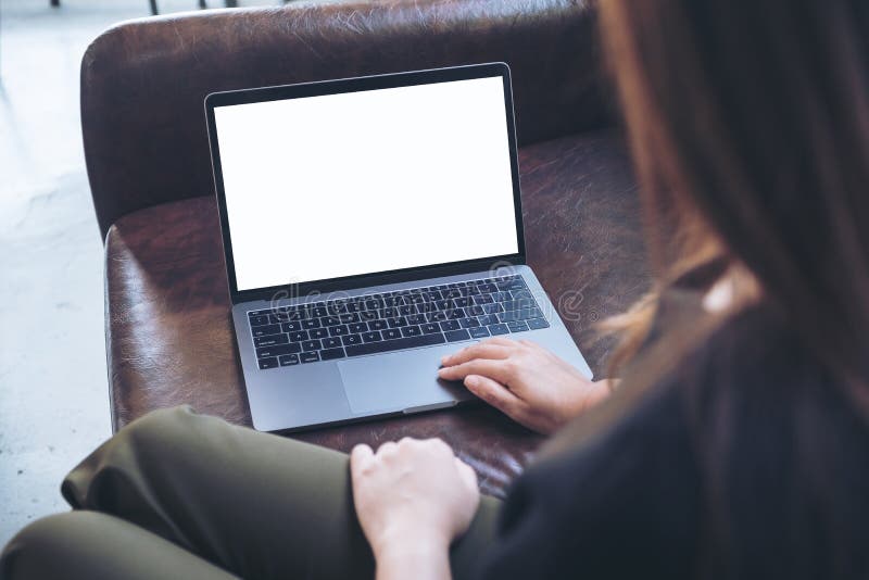 A woman using and looking at laptop with blank white desktop screen while sitting on sofa stock photos A woman using and looking at laptop with blank white desktop screen while sitting on sofa stock photos
