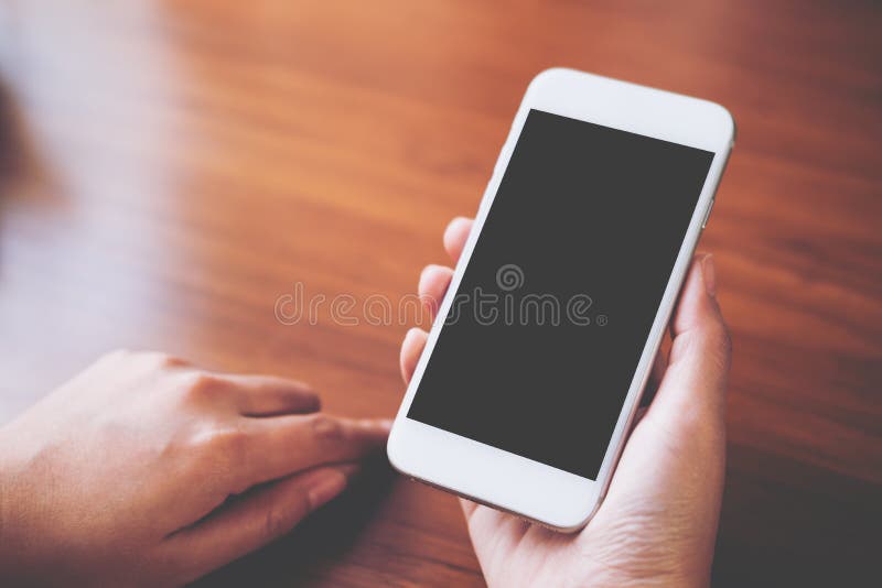 Mockup wizerunek ręki trzyma białego telefon komórkowego z pustym czerń ekranem z gorącą filiżanką obrazy royalty free
