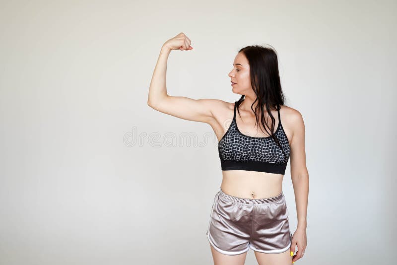 Mocny model, cienka dama w sporcie i majtki pokazujące muskuły na białym tle z kopią fotografia stock Mocny model, cienka dama w sporcie i majtki pokazujące muskuły na białym tle z kopią fotografia stock