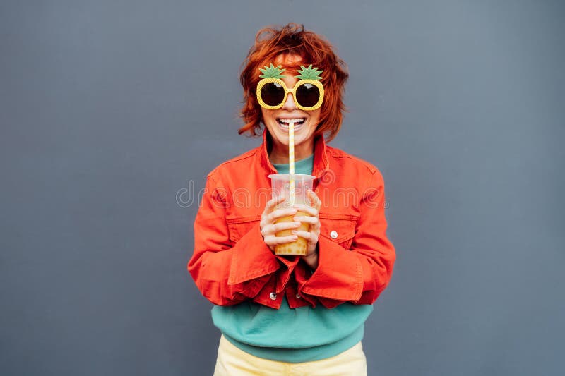 Moda Hipster Joven Mujer Con Ropa Brillante Y Gafas De Piña Bebiendo Fruta Azucarada Burbuja De Perlas De Tapioca Aromatizada Con Foto de archivo - de manera, 276811590