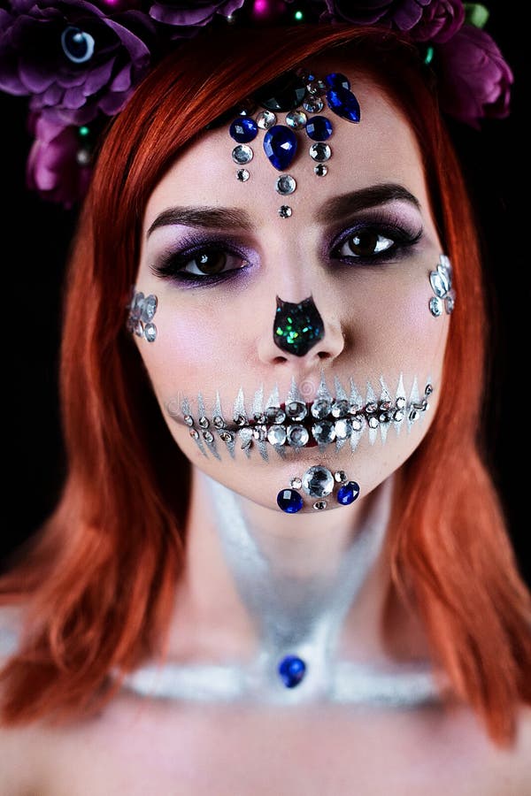 Fashion model with halloween skull makeup with glitter and rhinestones on black studio background. Fashion model with halloween skull makeup with glitter and rhinestones on black studio background