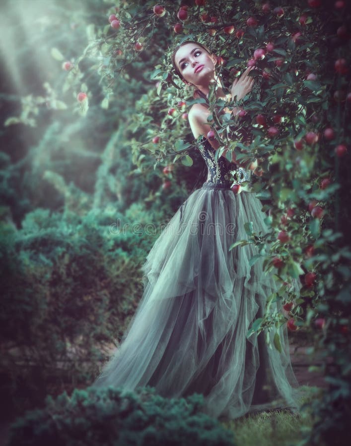 Moda modelo romántica de la muchacha de la belleza que presenta en los árboles del jardín, disfrutando de la naturaleza en manzan foto de archivo libre de regalías Moda modelo romántica de la muchacha de la belleza que presenta en los árboles del jardín, disfrutando de la naturaleza en manzan foto de archivo libre de regalías