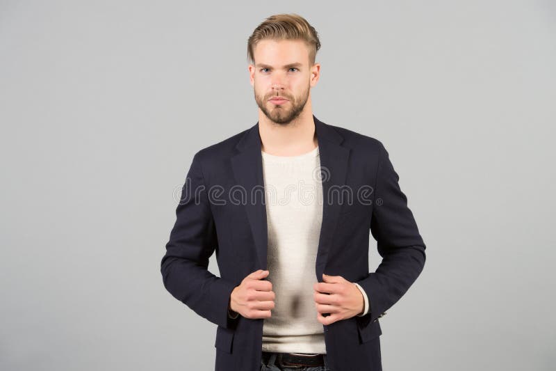 Aspecto profesional con apariencia informal de negocios hombre de negocios  que elige una chaqueta de traje para un código de vestimenta informal hombre  barbudo que se viste para un evento informal de