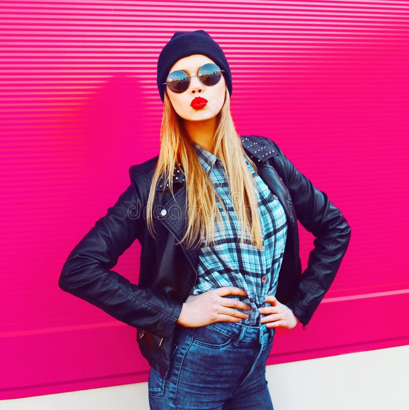 Moda portreta blondynki dziewczyny dosłania cukierki powietrza chłodno buziak pozuje w rockowej czerń stylu kurtce, kapelusz pozu obraz stock Moda portreta blondynki dziewczyny dosłania cukierki powietrza chłodno buziak pozuje w rockowej czerń stylu kurtce, kapelusz pozu obraz stock