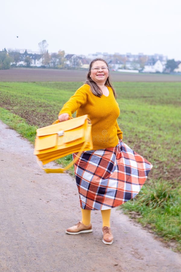 Mode de vie naturel femme joyeuse dans les lunettes profiter de la marche extérieure assortis accessoires jaune mode de vie rural images stock