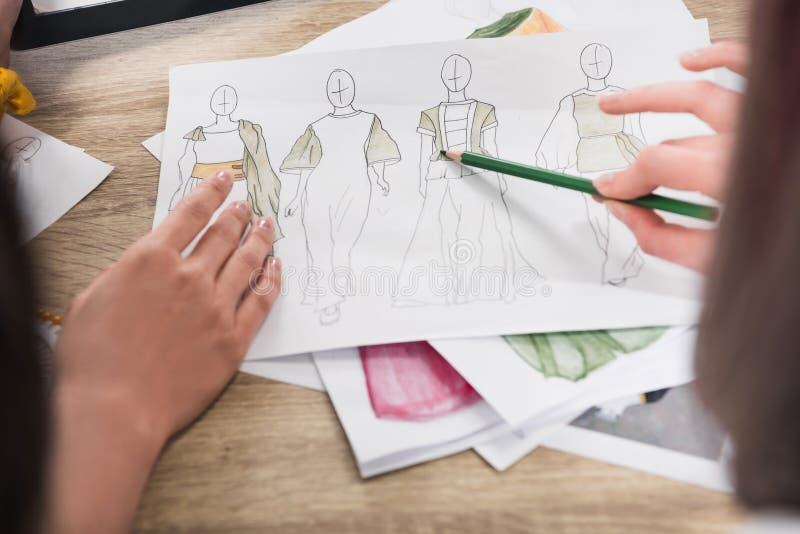 Modeformgivare som arbetar med ritningar av modeller arkivbilder Modeformgivare som arbetar med ritningar av modeller arkivbilder