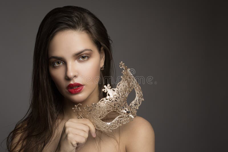 Modefrau mit dem langen Haar und rotem Lippenstift mit goldener Maske lizenzfreie stockfotos Modefrau mit dem langen Haar und rotem Lippenstift mit goldener Maske lizenzfreie stockfotos