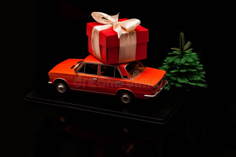 Model of Car with a Gift on the Roof. on a Black Background with a