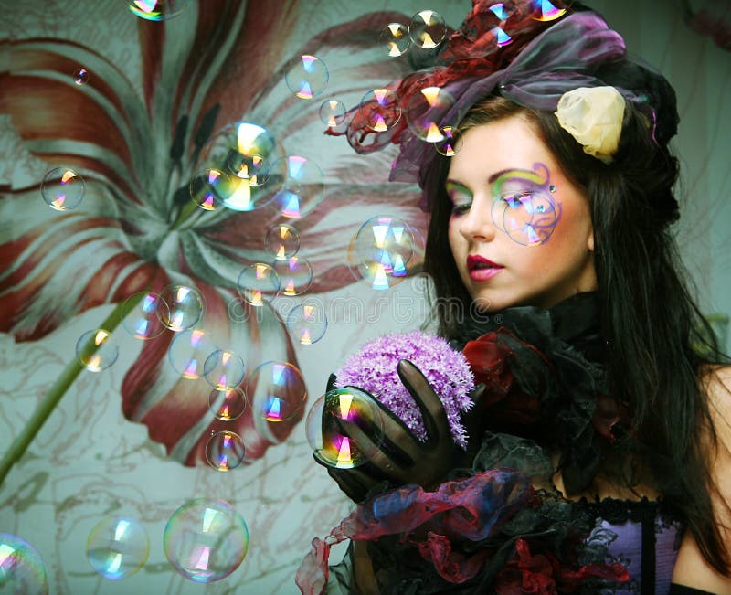 Model With Creative Make Up Blowing Soap Bubbles Stock