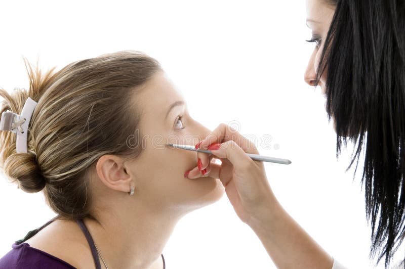 Model getting eye makeup from beautician