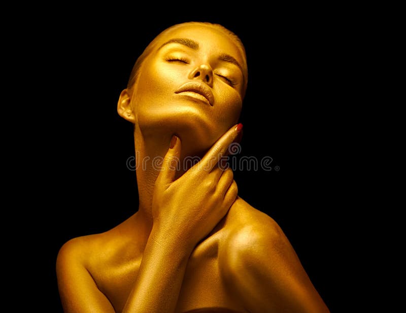 Model girl with shiny golden professional makeup over black. Beauty sexy woman with golden skin. Fashion art portrait closeup