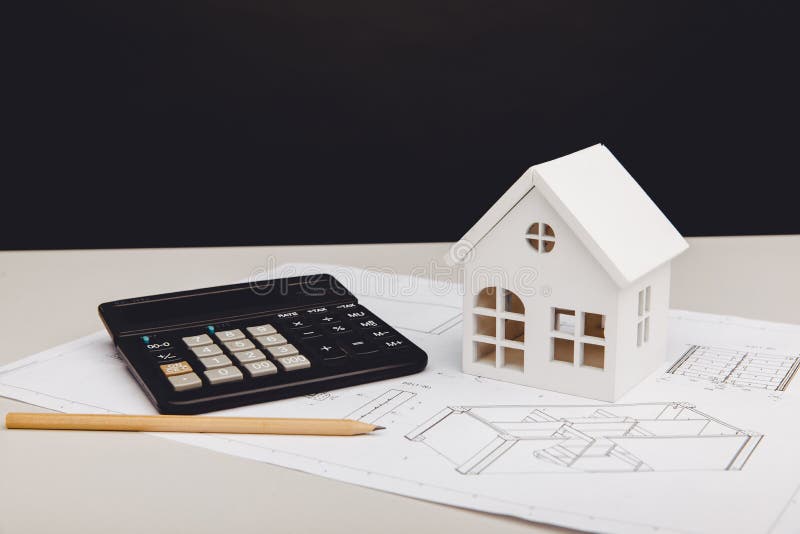 Model of House and Calculator on Architectural Project. House Building