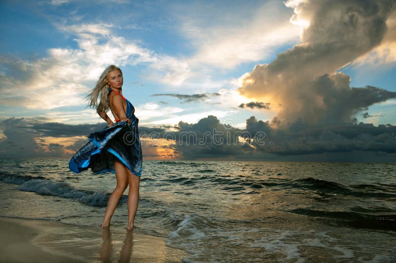 Model posing in beach dress at early morning sunrise