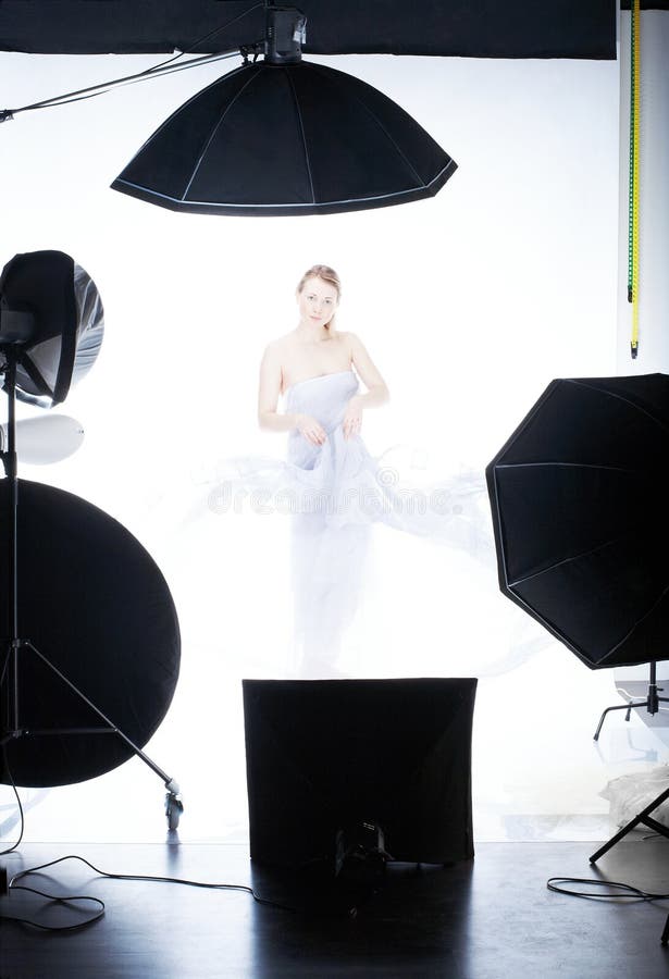 Photographer Working with a Cute Model in a Professional Studio Stock