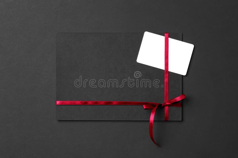 Model van witte giftkaart op groetkaart met rode boog bij zwarte stock fotografie Model van witte giftkaart op groetkaart met rode boog bij zwarte stock fotografie