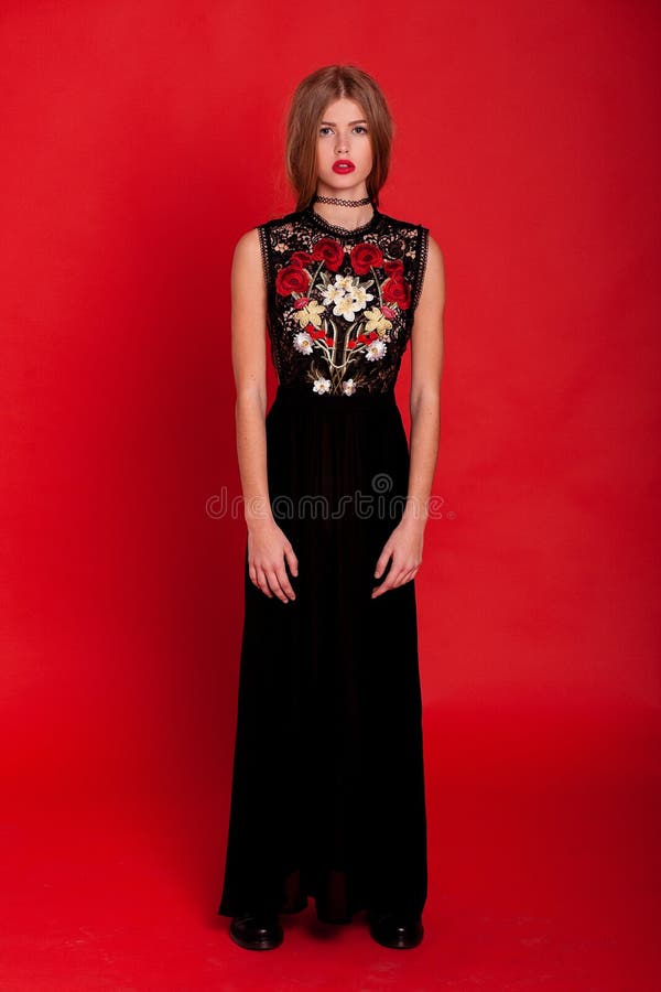 Modele En El Vestido Negro Largo Presenta Fondo Rojo Imagen de archivo - Imagen de estudio, alineada: 127977179
