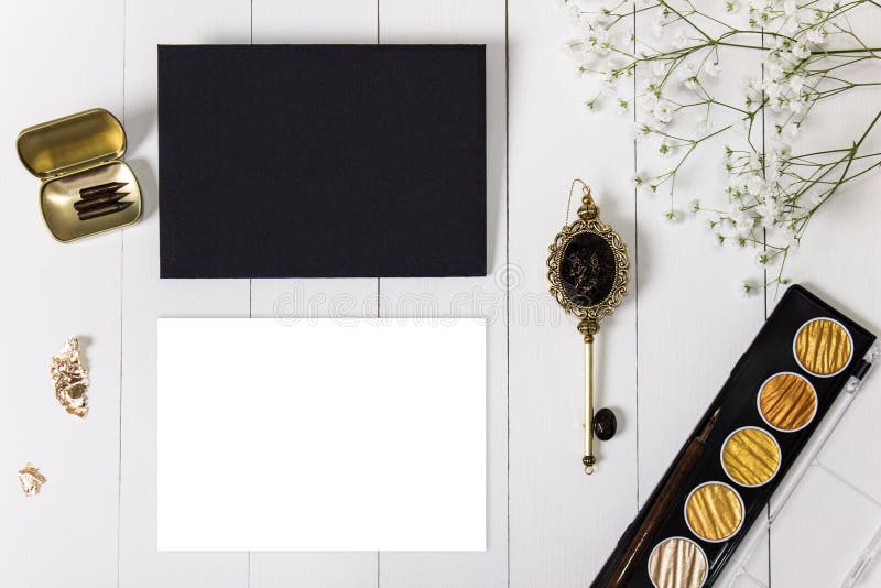 Modell med kuvertet, det tomma kortet för guld- färgpulver och blommor arkivbild Modell med kuvertet, det tomma kortet för guld- färgpulver och blommor arkivbild